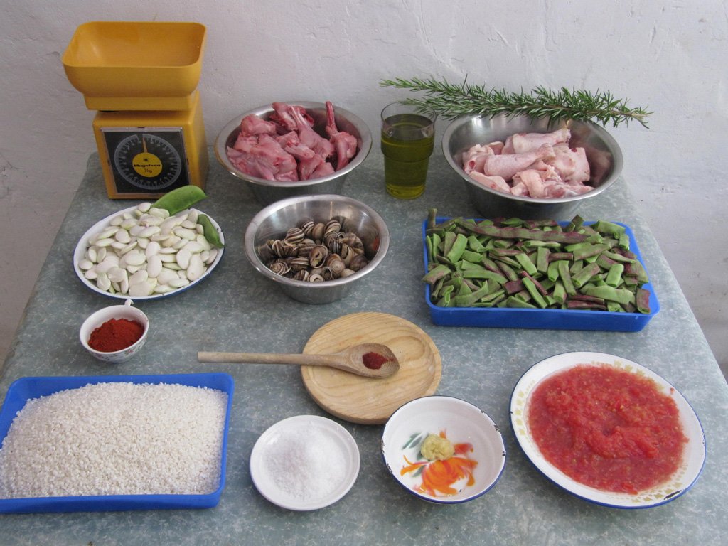 The traditional ingredients of a Valencian or Meat Paella, based on chicken and rabbit, plus tomato, beans, olive oil, basil, saffron, paprika, salt and obviously, Bomba rice