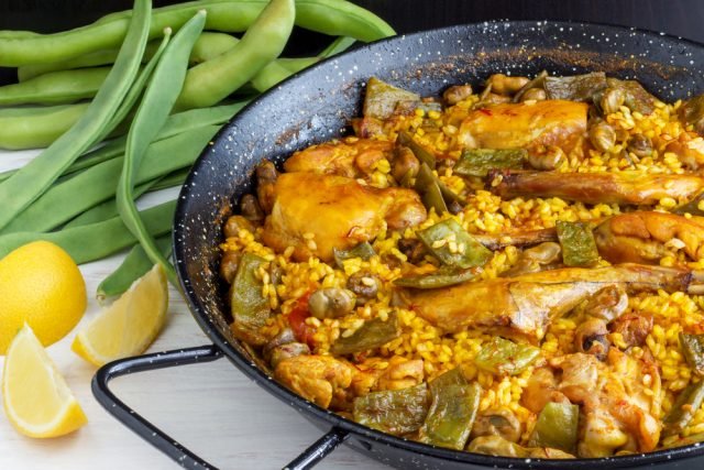 A delicious Valencian Paella based on Chicken and Rabbit, accompanied by Green Beans and some Lemon